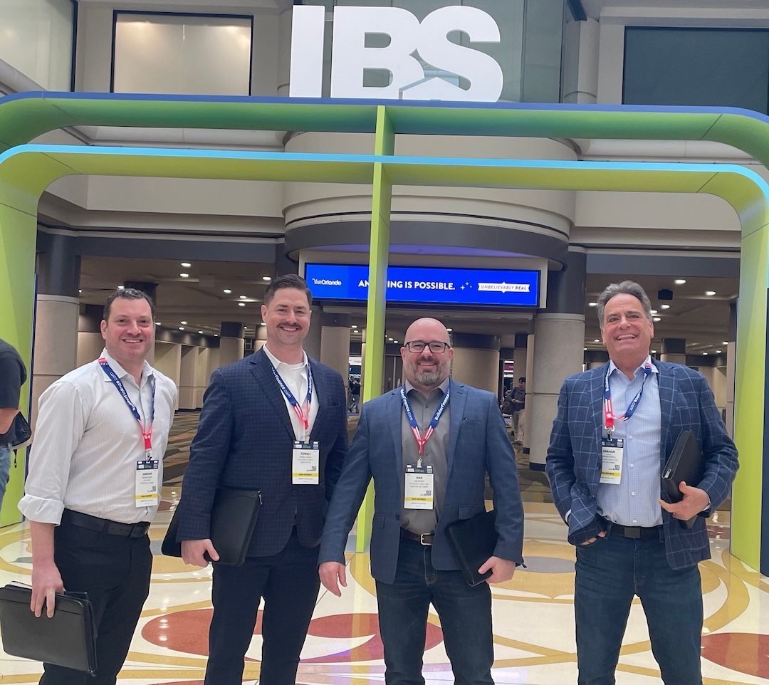 Two images. One of a man standing in front of a sign AHR Badge Pick Up and the other of a crowd on a convention floor.