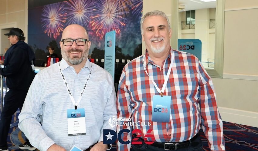 A group of people are standing around a table in a conference room.