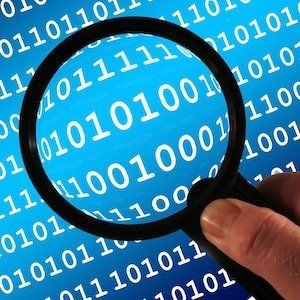 A person is holding a magnifying glass over a blue background of binary code