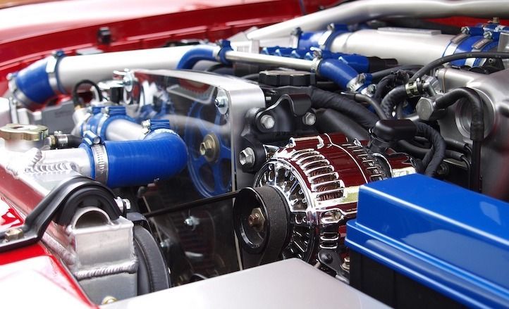 A close up of a car engine with blue hoses