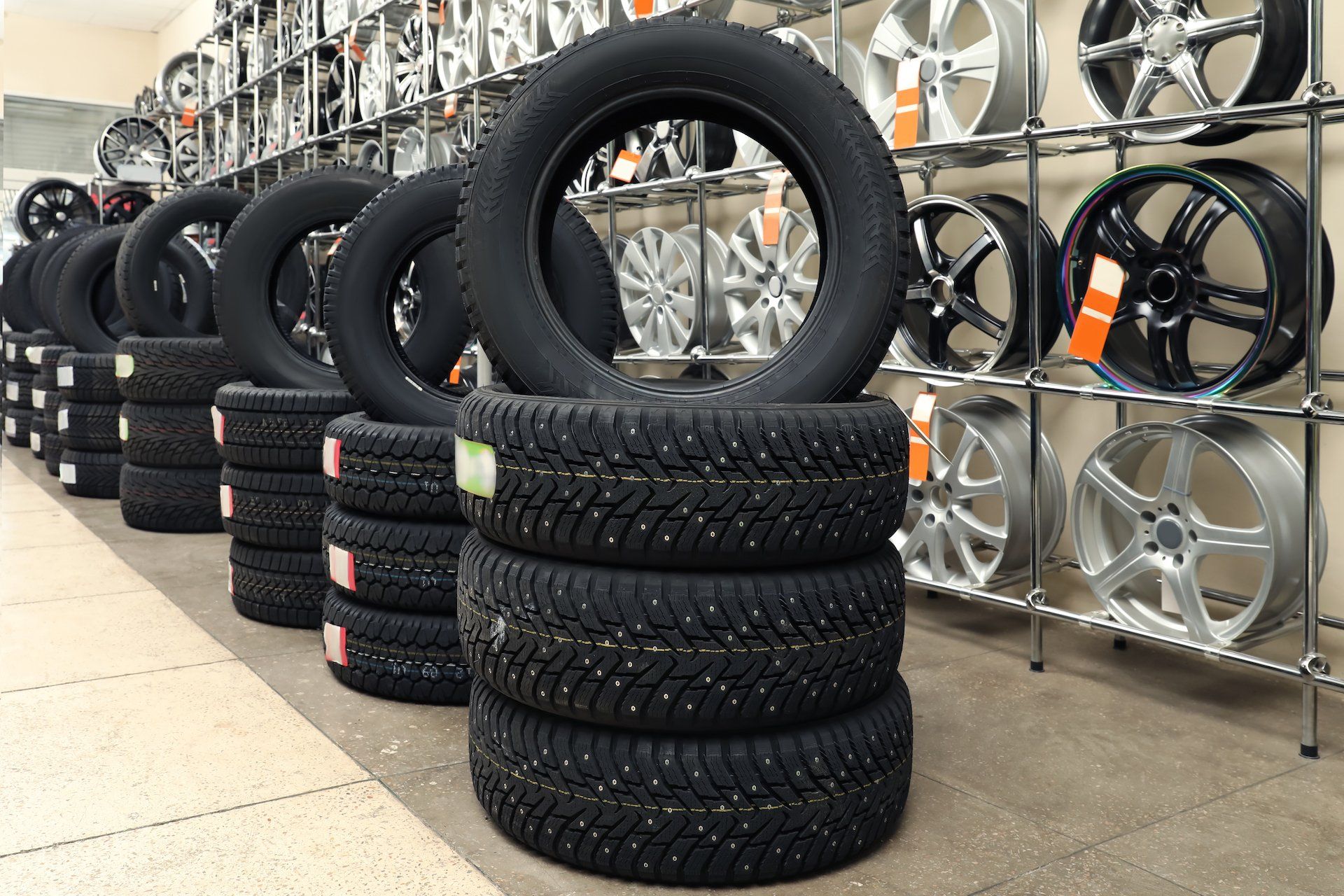 A bunch of tires are stacked on top of each other in a store.