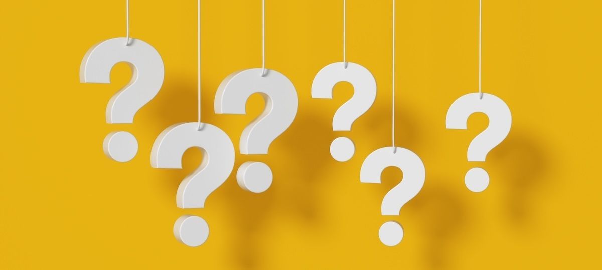 6 question marks, each dangling from a wire, in front of yellow background
