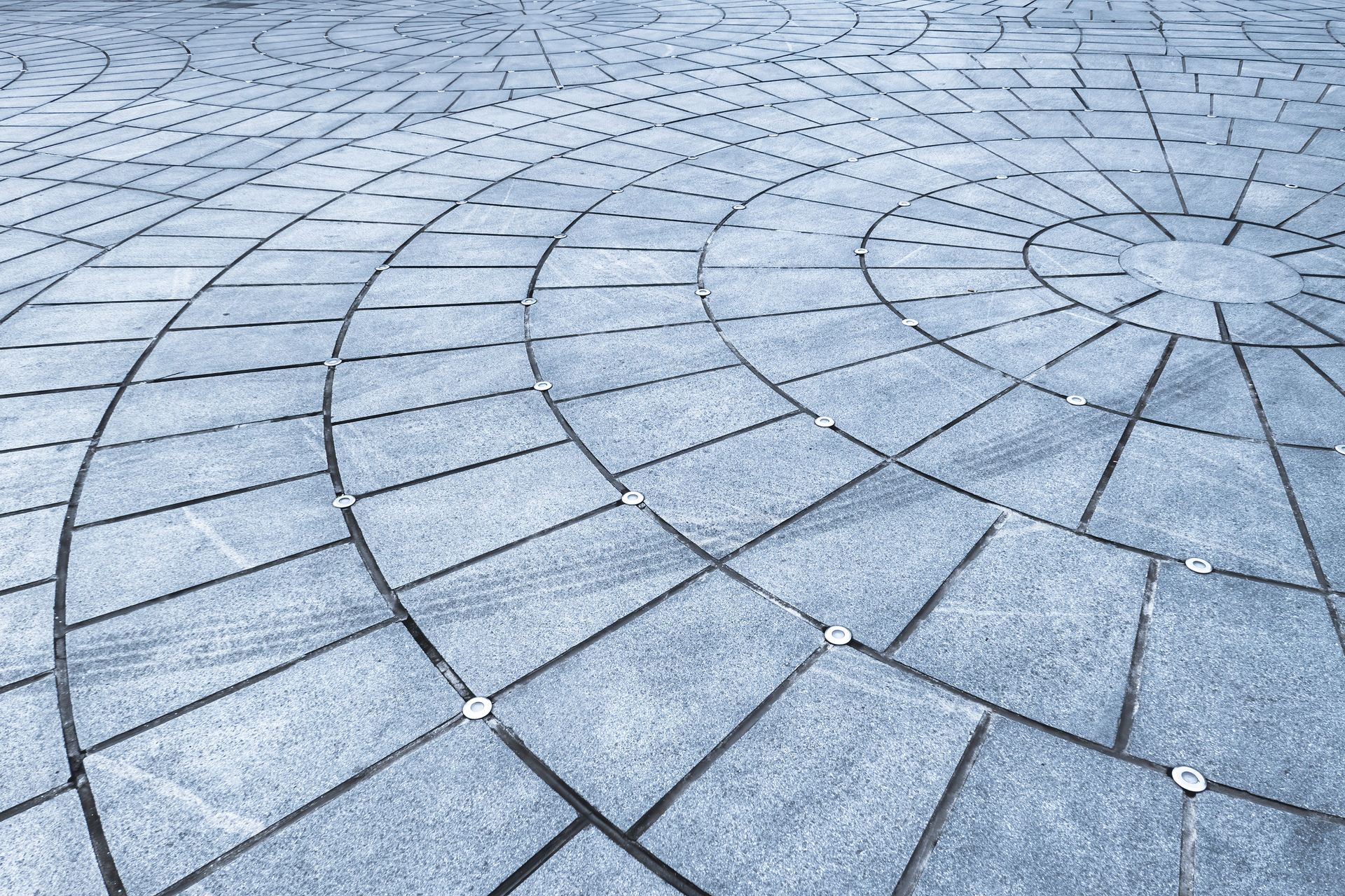 A circular pattern of bricks on a concrete floor.