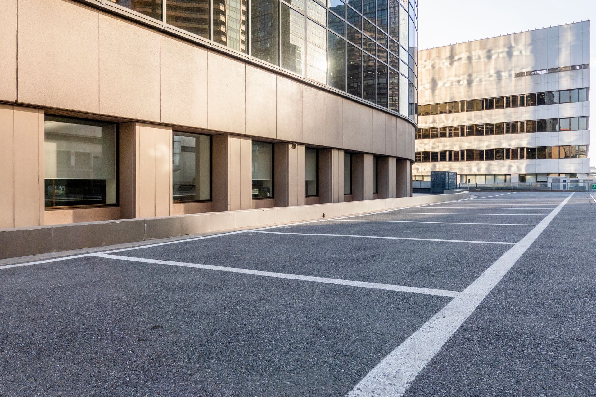 An empty parking lot in front of a large building.