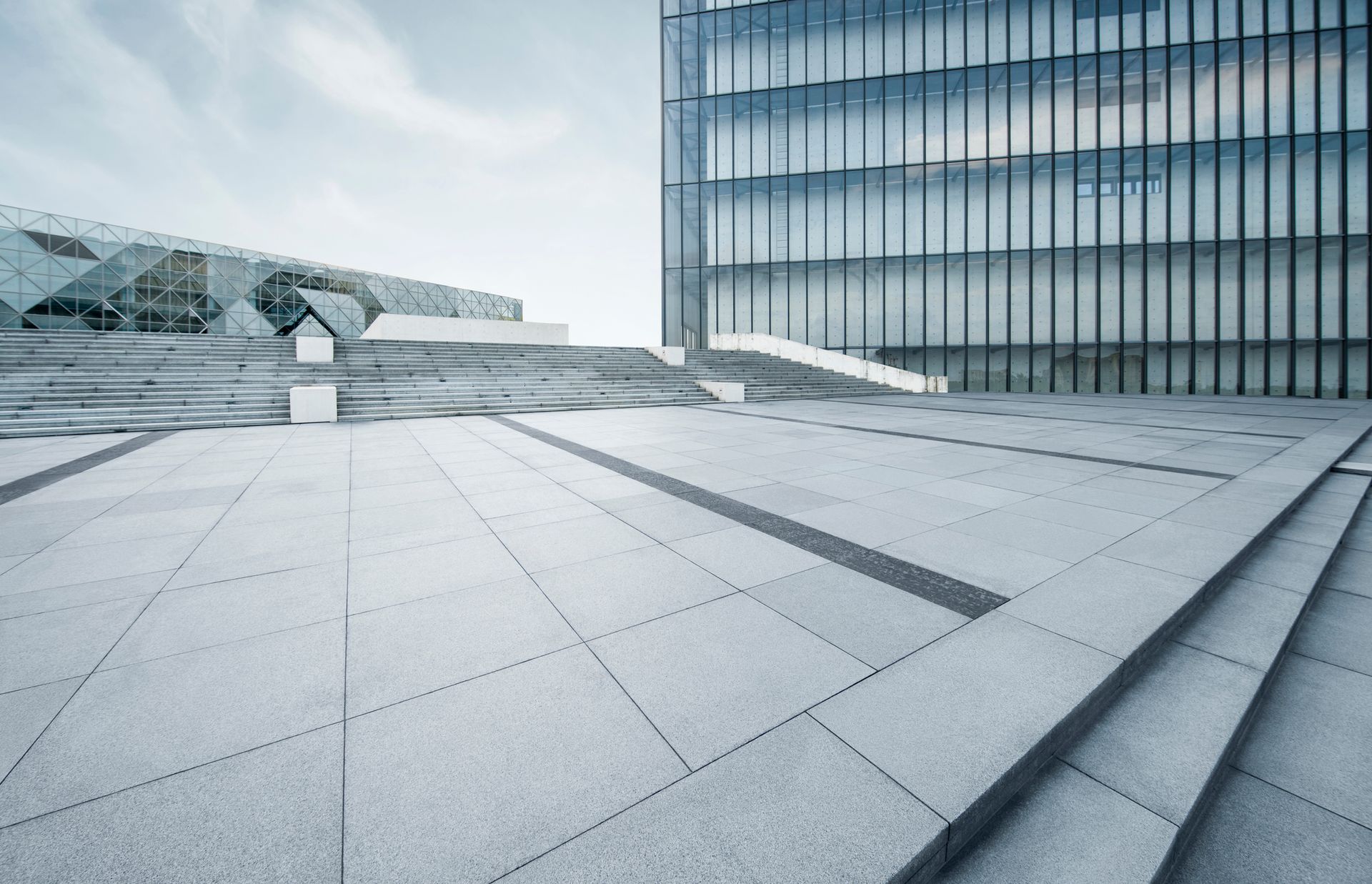 An empty square with stairs and a building in the background.