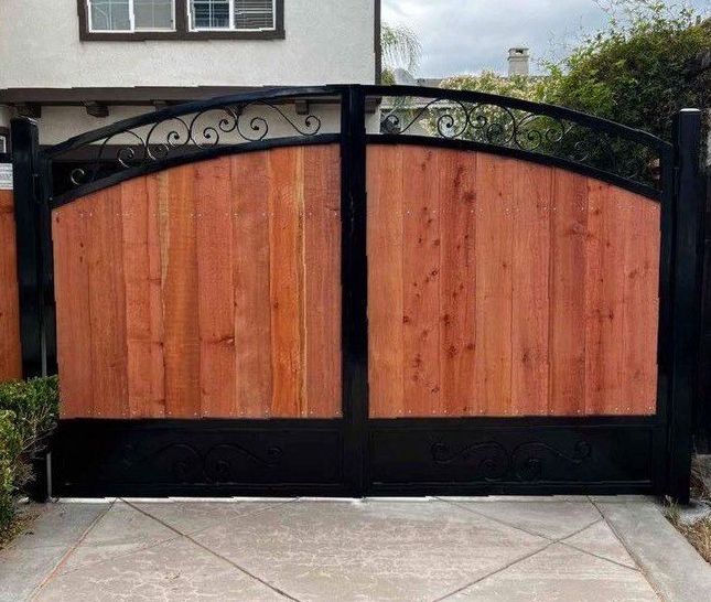 A large white house with a gated driveway leading to it.