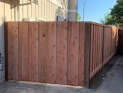 A wooden fence is sitting on the side of a road.