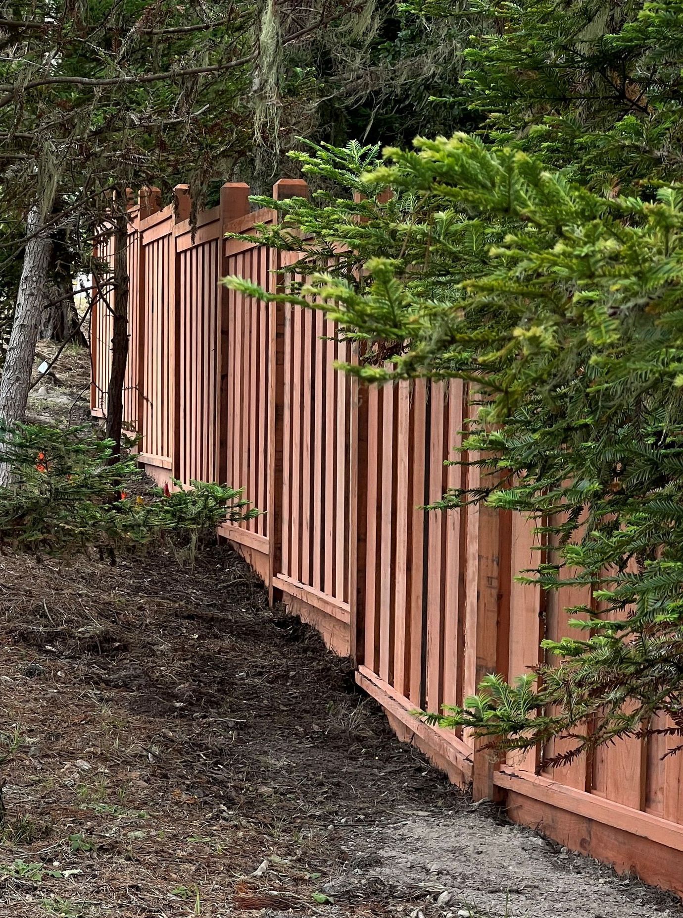 A wooden fence is in front of a house.