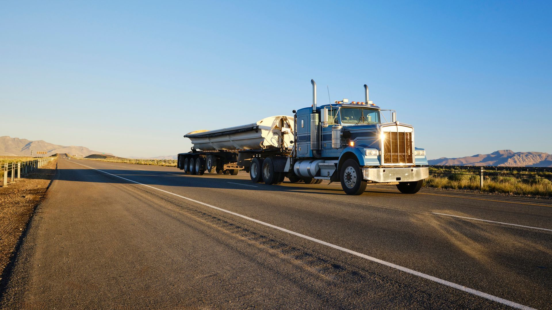 Large semi truck hauling freight on the open highway in the western USA. Large semi truck hauling freight on the open highway in the western USA.