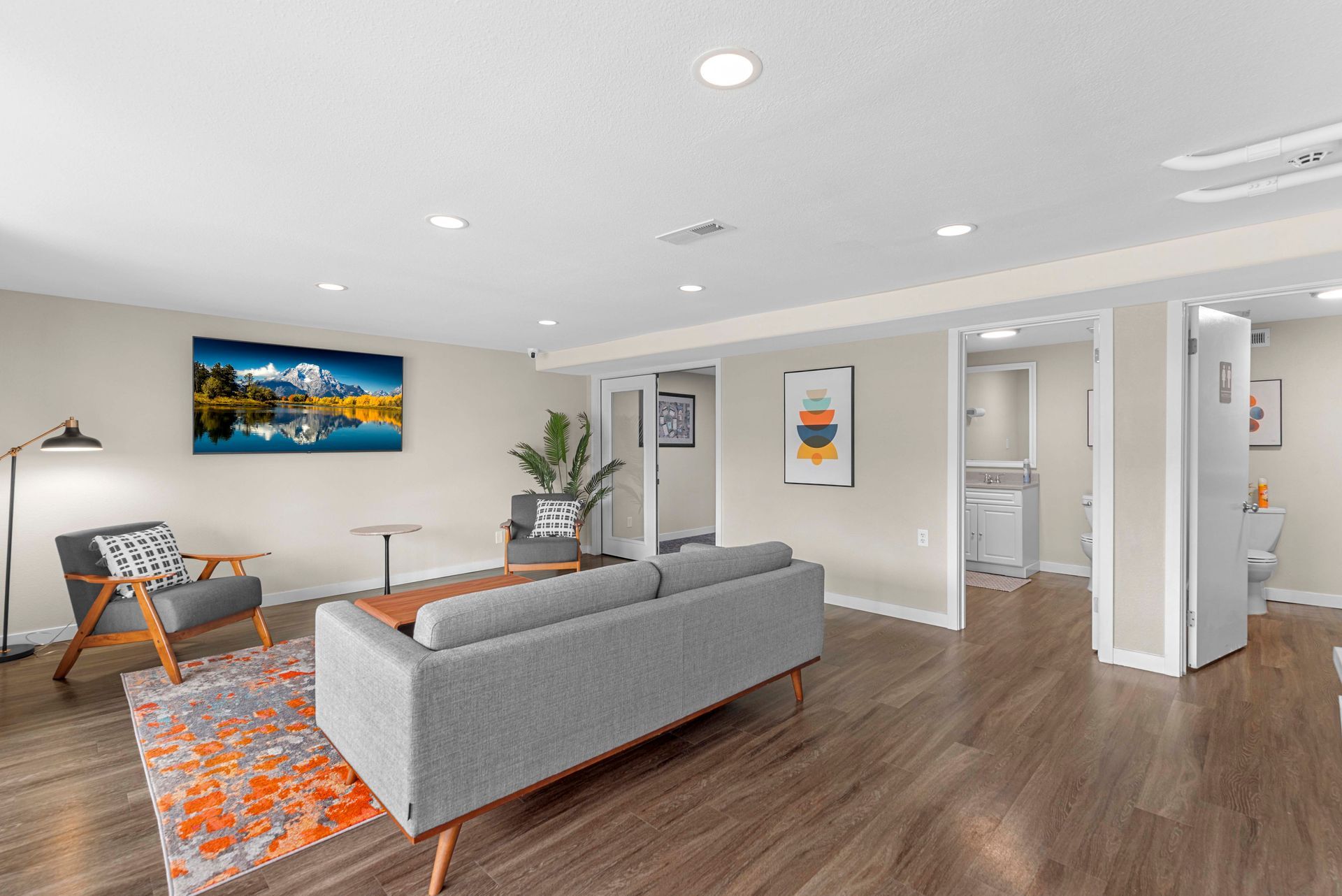 A living room with a couch , chairs , and a rug.
