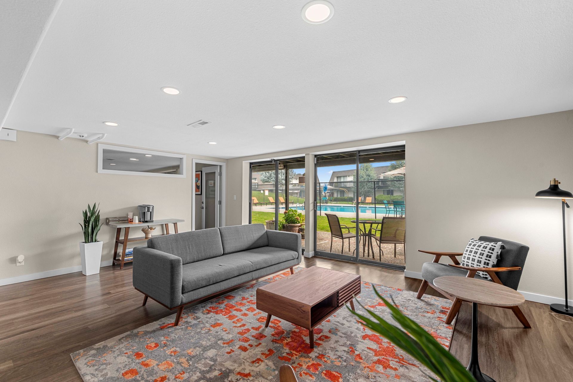 A living room with a couch , chairs , table and rug.