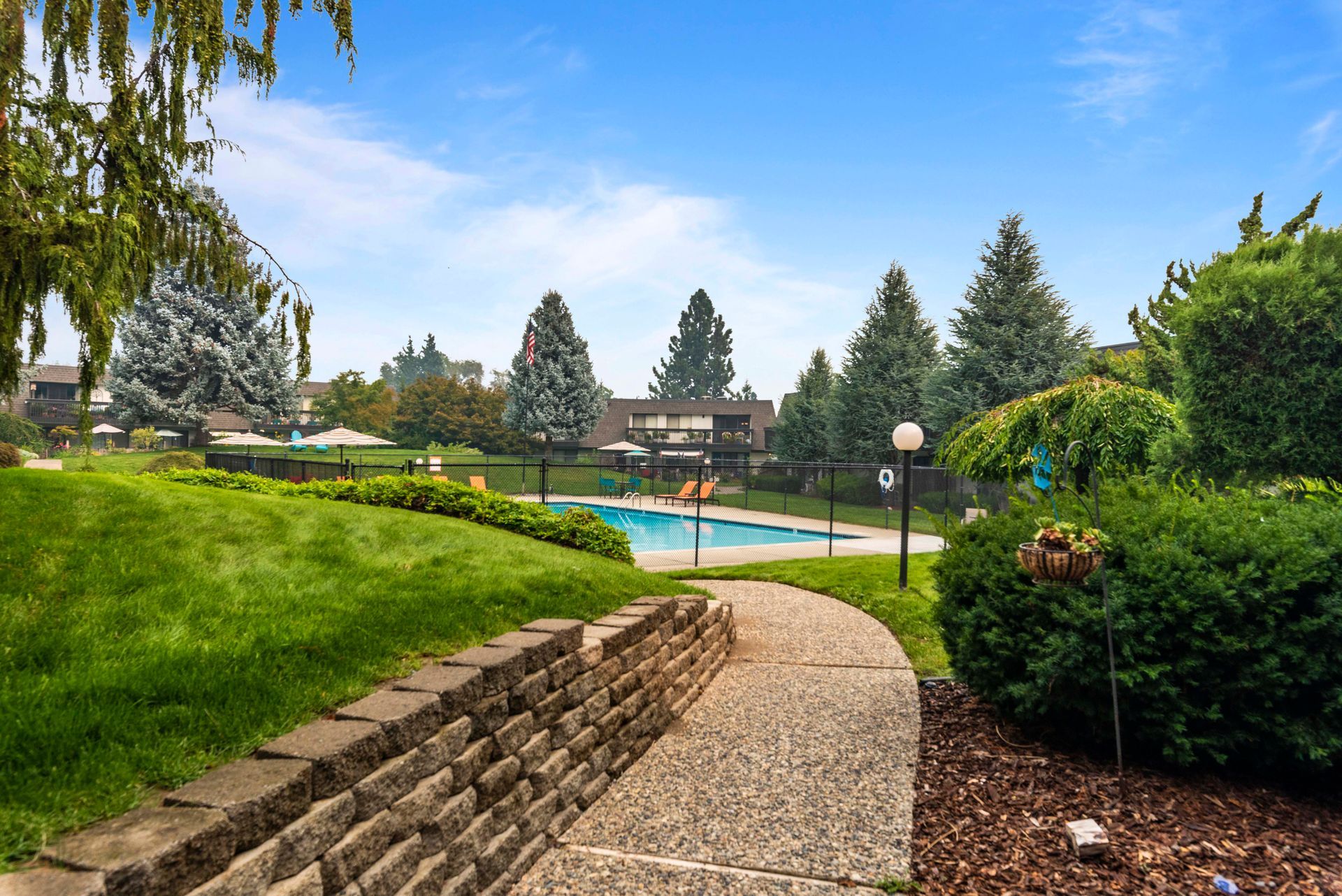 A walkway leading to a swimming pool in a park.