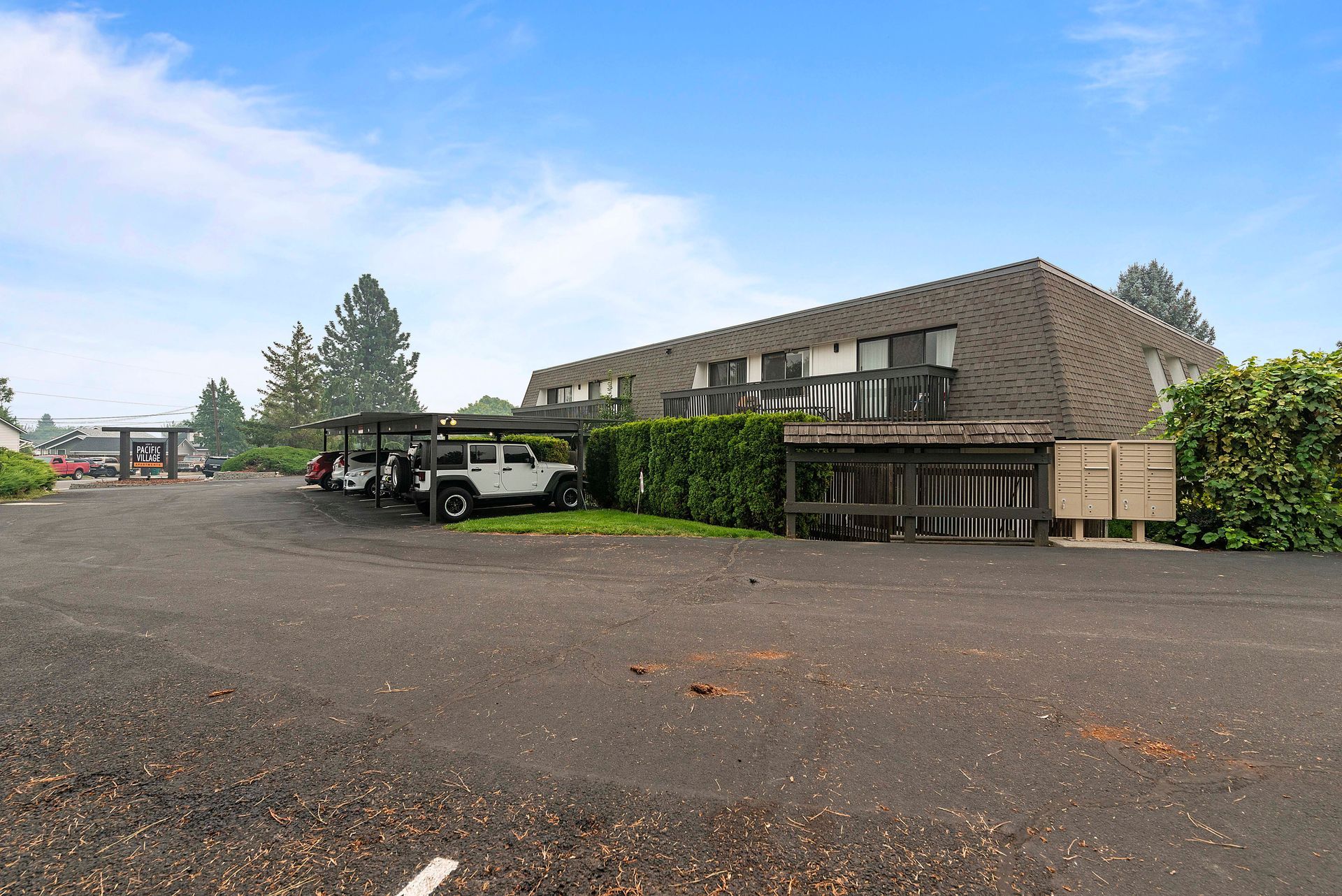 A parking lot with cars parked in front of a building.