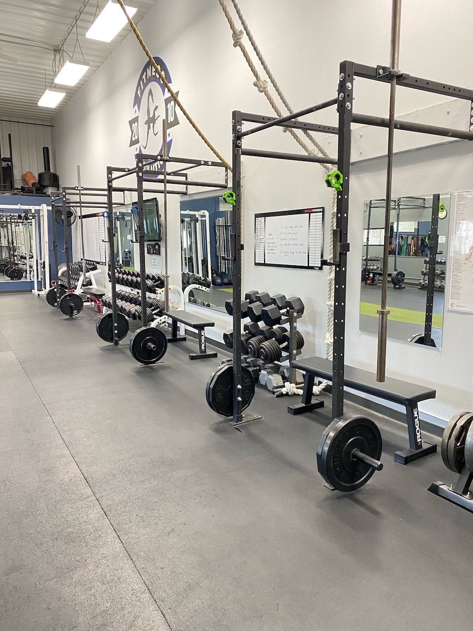 A gym with a lot of weights and benches