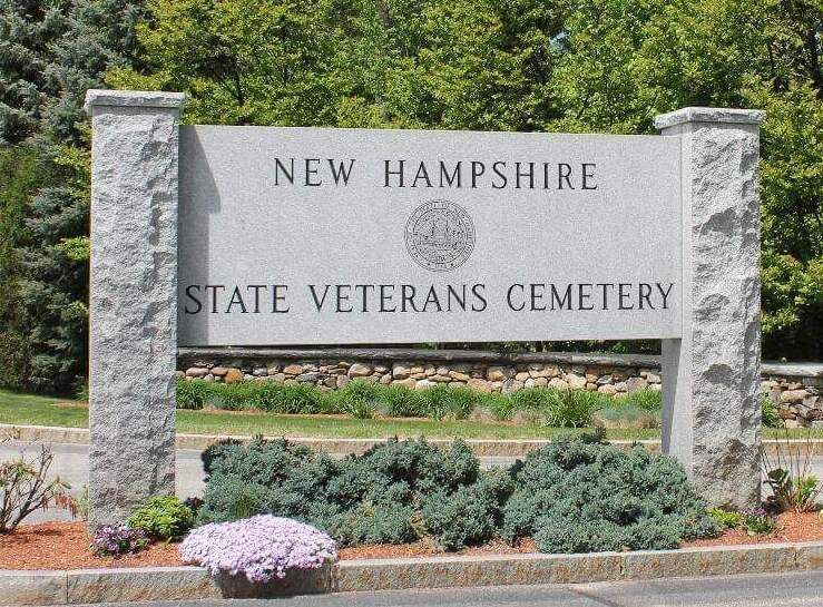 Sign for New Hampshire State Veterans Cemetery with text on a granite structure.