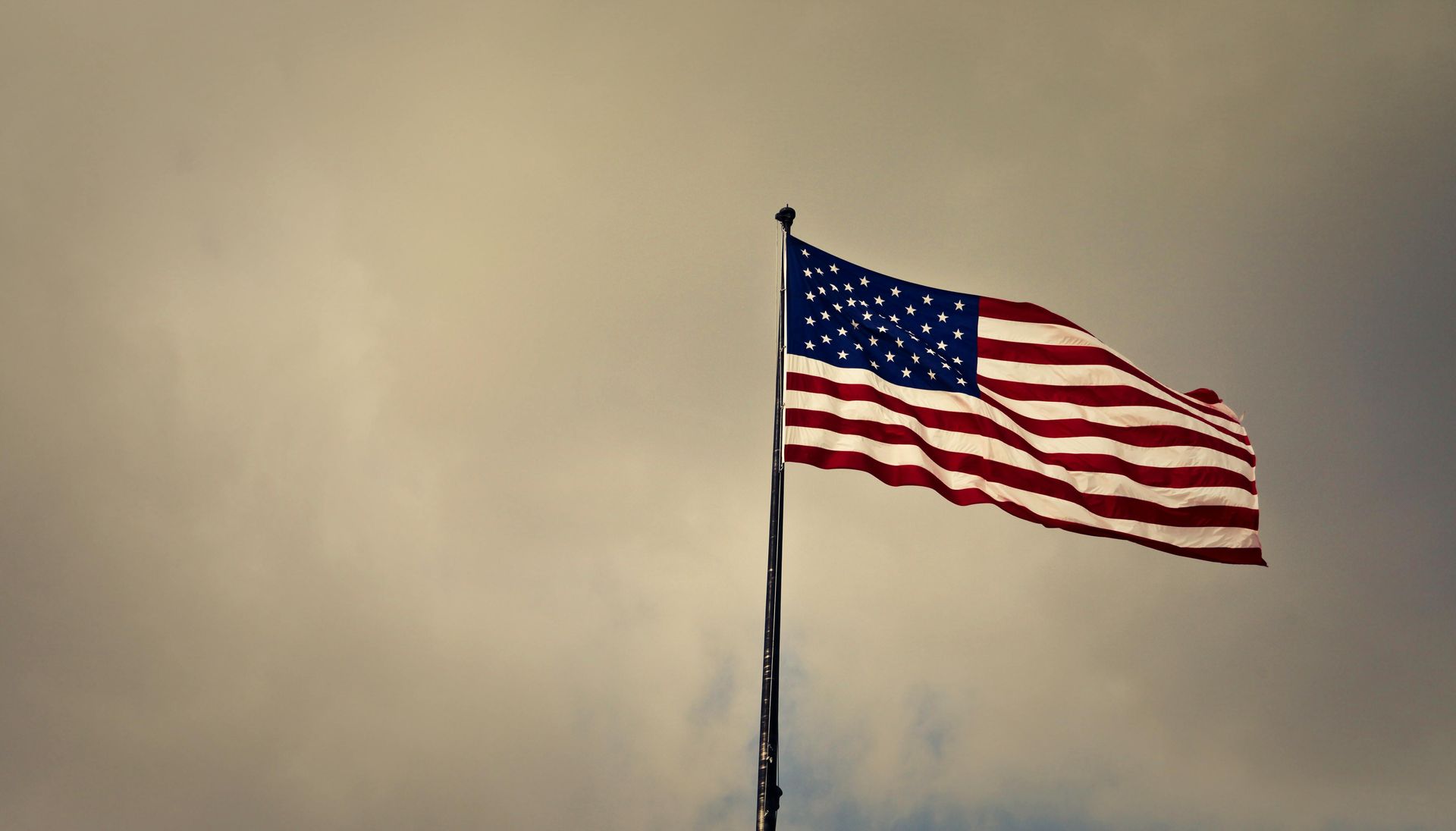 American flag with red and white stripes and blue field of white stars.