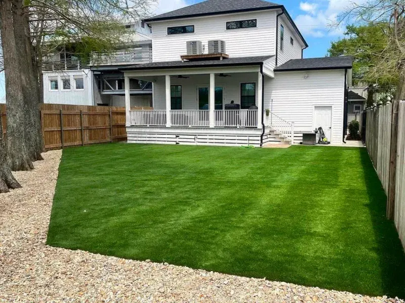 A large brick house with a large lawn in front of it.