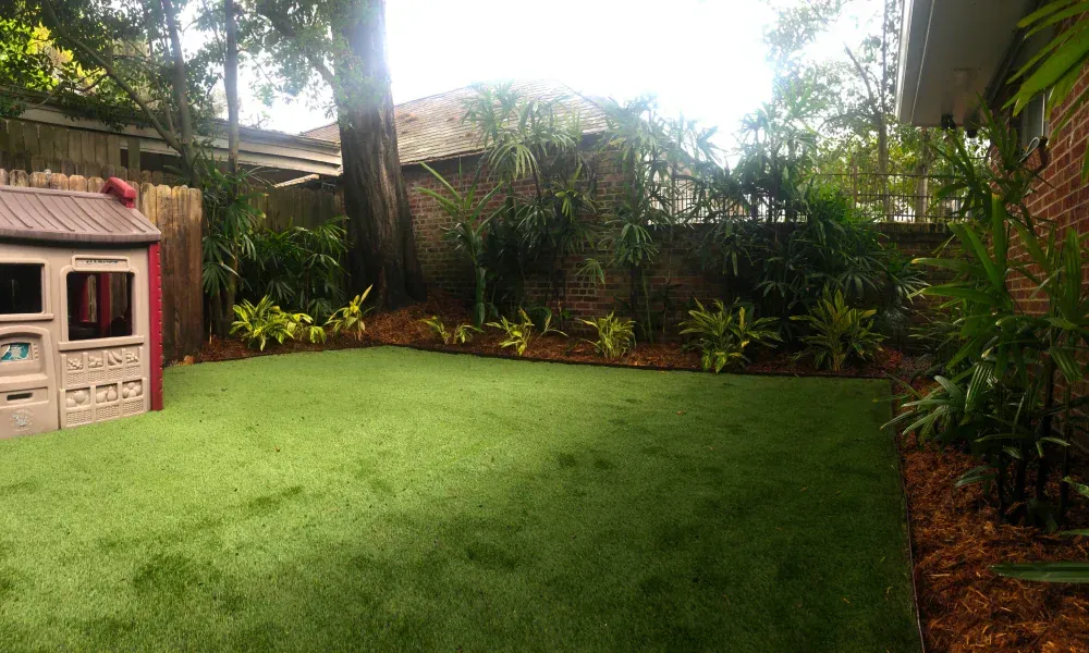 A backyard with a playhouse and a lush green lawn.