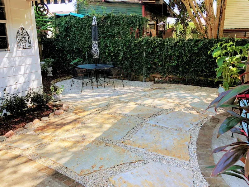 A patio with a table and chairs in front of a house.