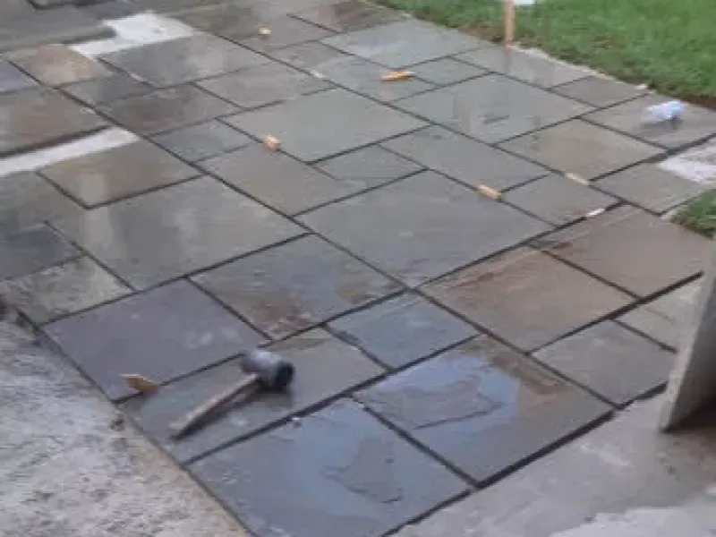 A hammer is laying on top of a brick walkway.