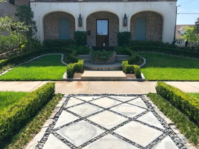A brick house with a concrete walkway leading to it
