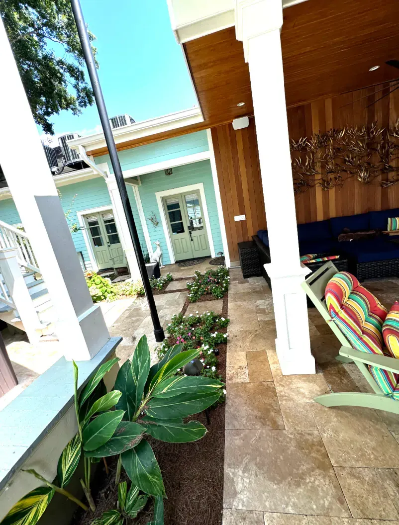 A porch with a rocking chair and a couch in front of a house.