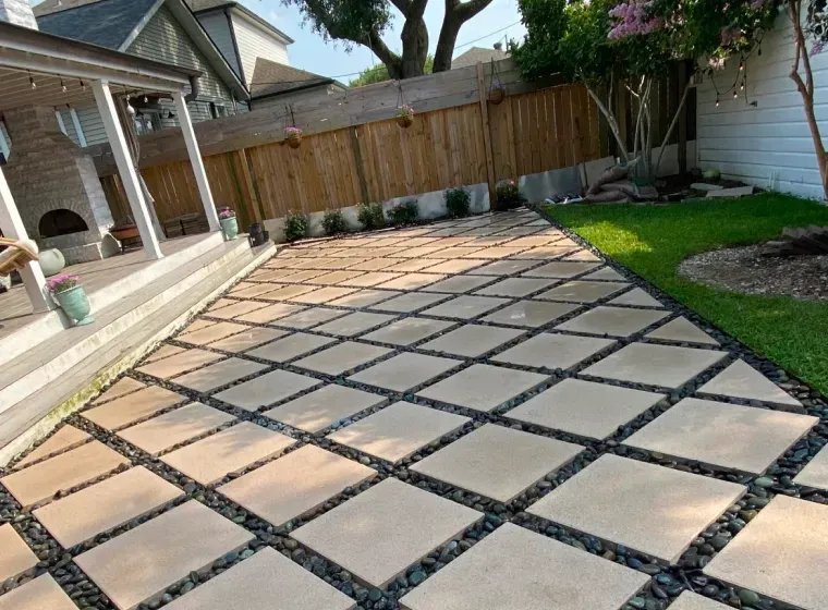 A patio with a fence and a porch in the backyard of a house.