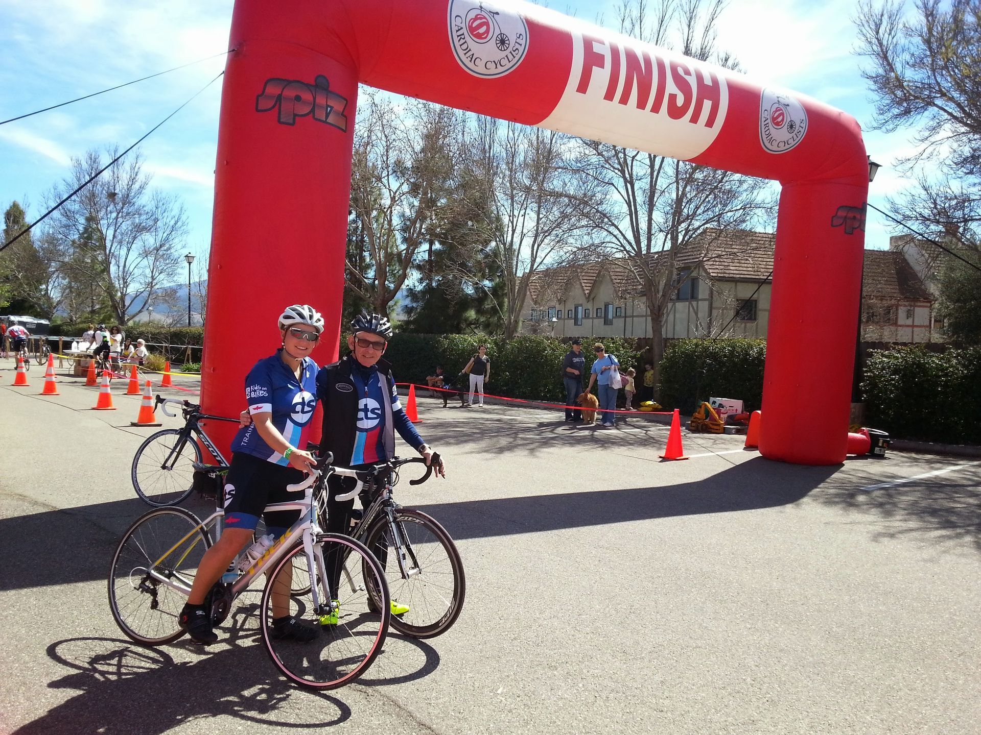 Couple on bicycles at race finish line banner