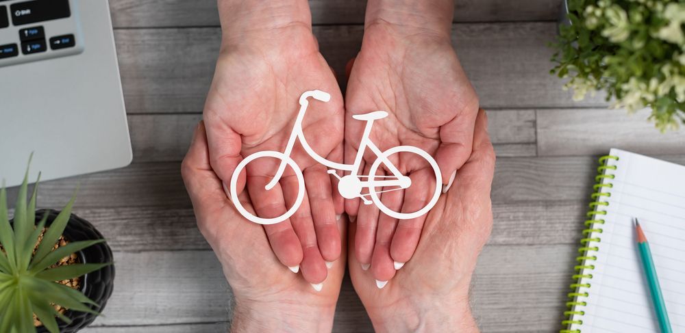 Helping hands holding a small bicycle