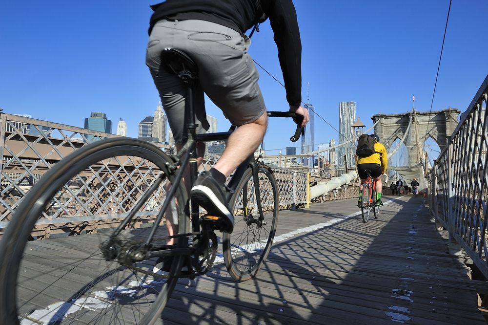 Cyclists riding bicycles across the Brooklyn Bridge in NYC