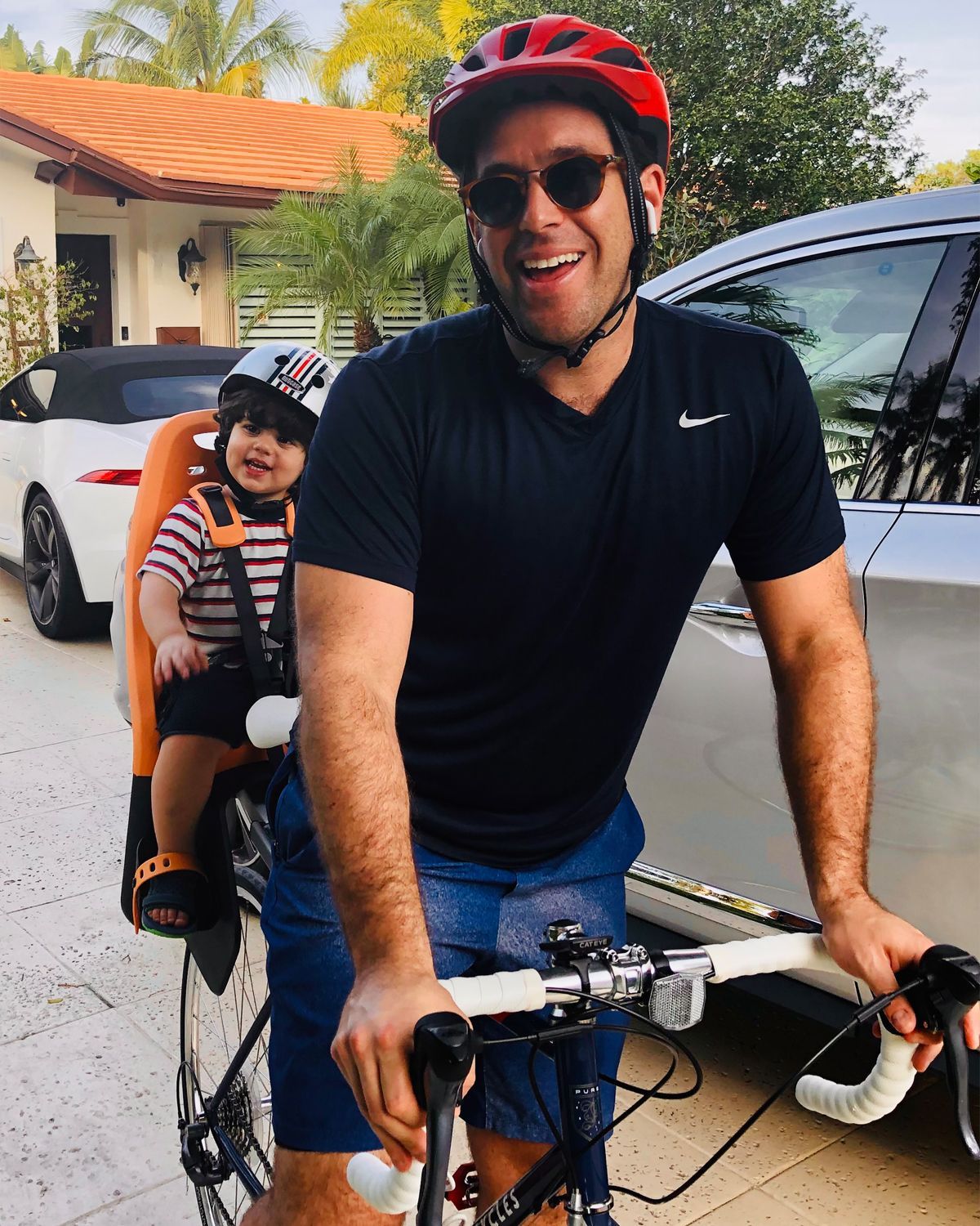 Kyle Newman is riding his bike with his son in a child seat.