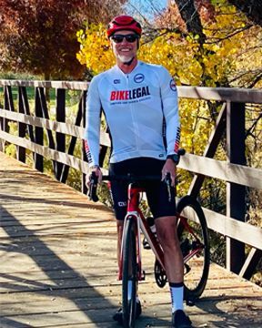 Mark Strohman on his bicycle on a wooden bridge