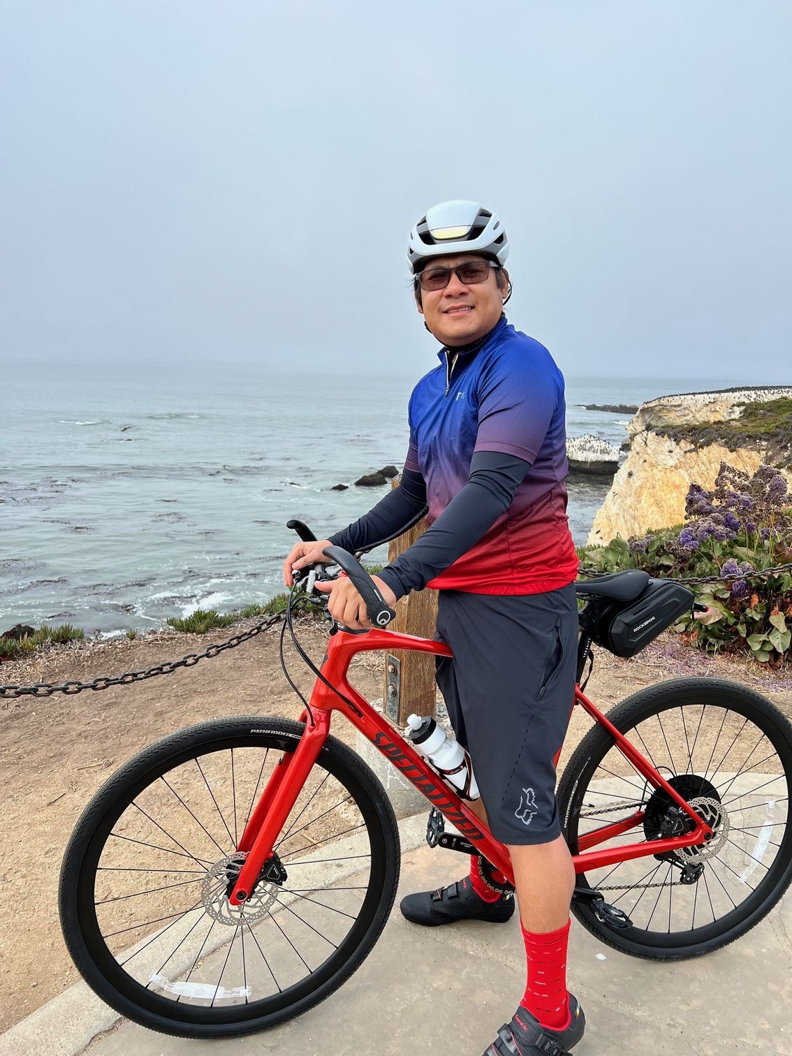 Matt Danh, Managing attorney at Bike Legal on his bicycle near the ocean.