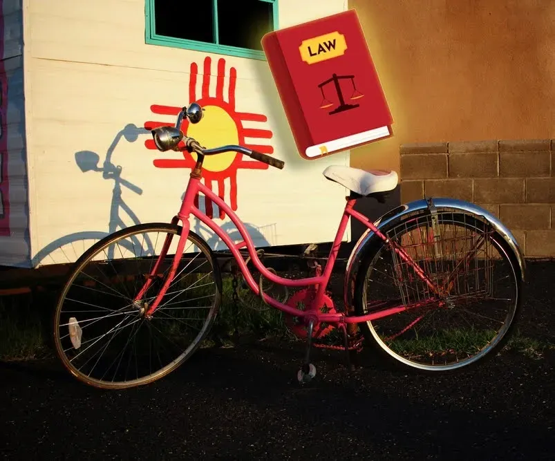 bicycle in front of a building with the New Mexico state flag, with a law book.  New Mexico Bicycle 