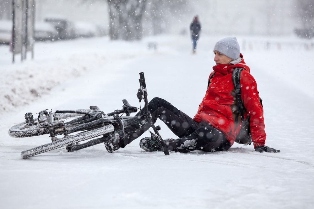 Bicycle rider who fell off his bike while cycling on a snowy road