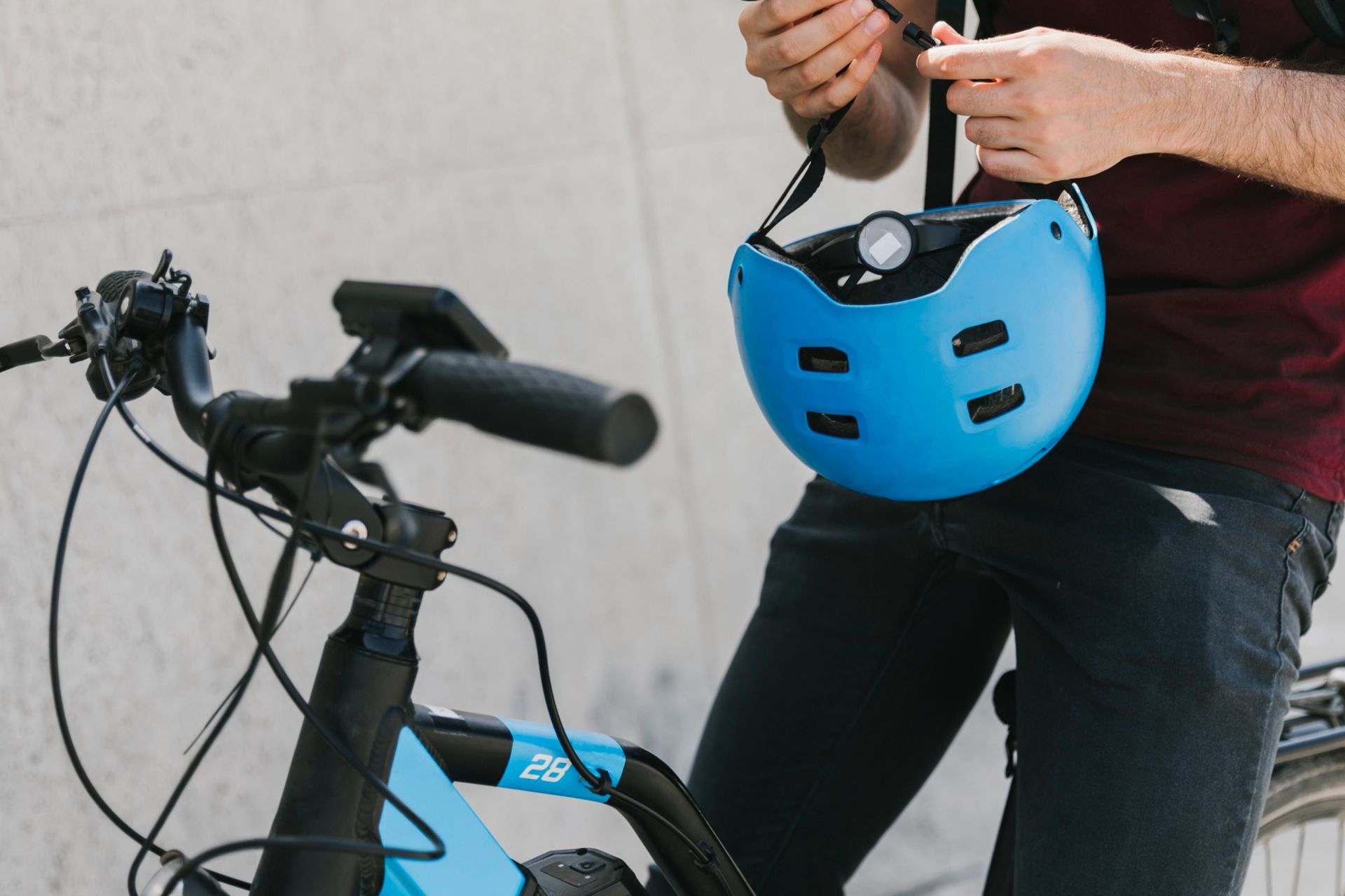 man on a bicycle holding a blue helmet