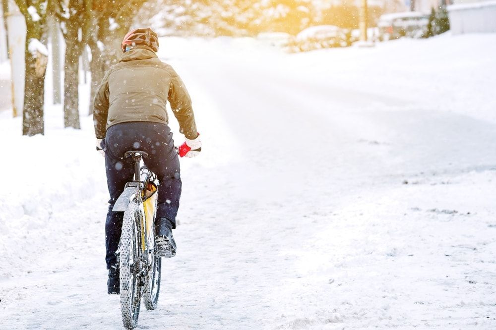 Cyclist riding his bike on a snow packed bike path winter cycling