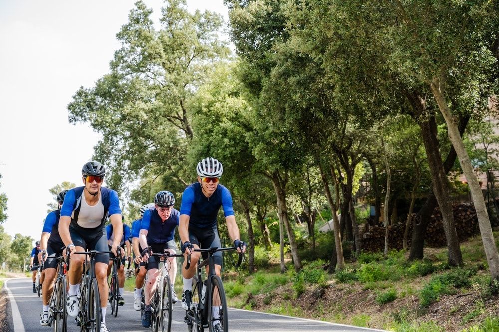 group of cyclists peloton riding on the road