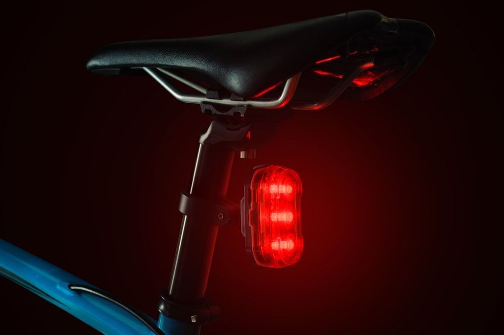 Red bicycle tail light illuminated rear bike light attached to seat post