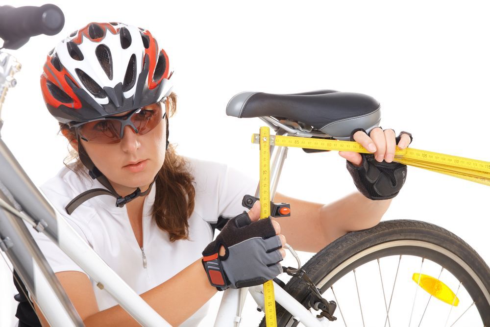 Female cyclist adjusting seat height on bicycle