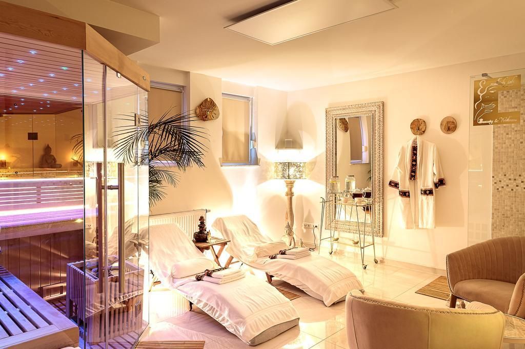 Ein Wohnzimmer mit Couch, Sesseln und Private Sauna.