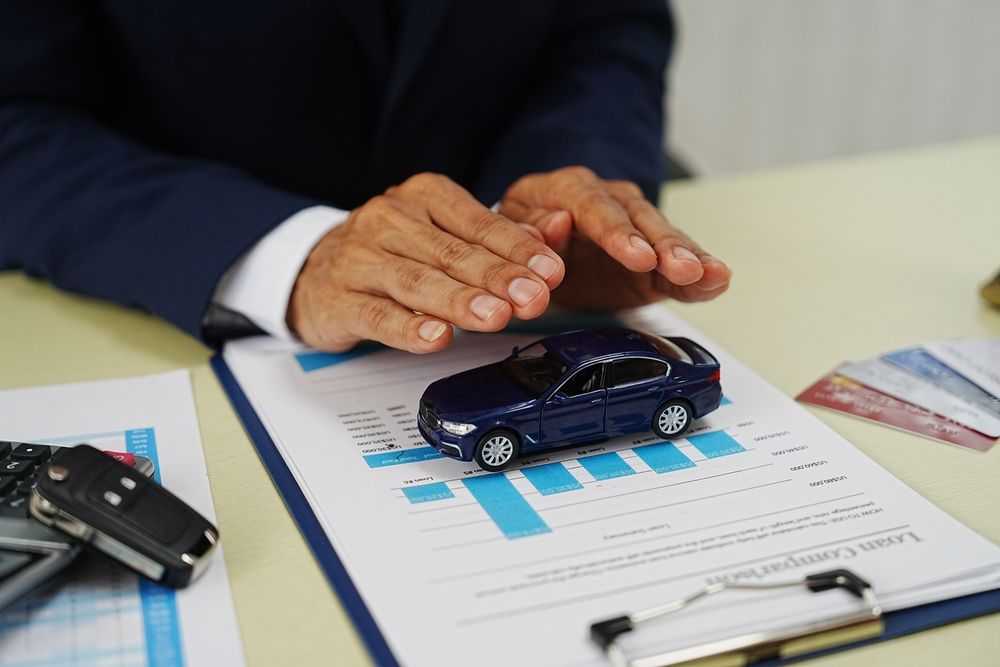 A man is holding a toy car on top of a clipboard.