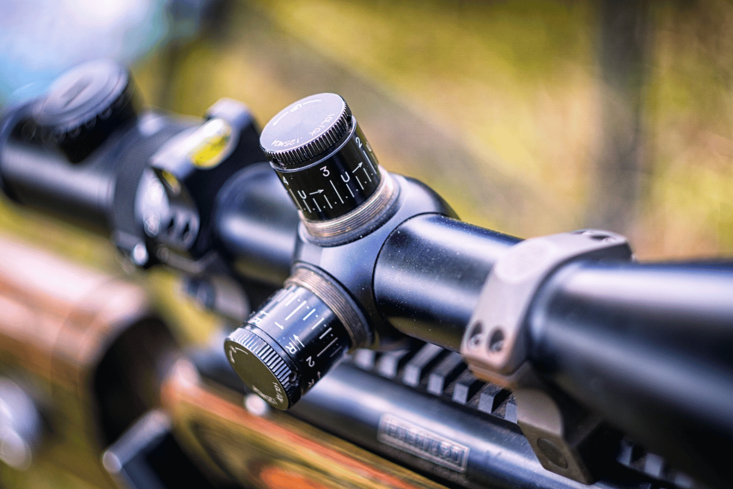 Four rifles with scopes, in cases, various finishes, likely for sale.