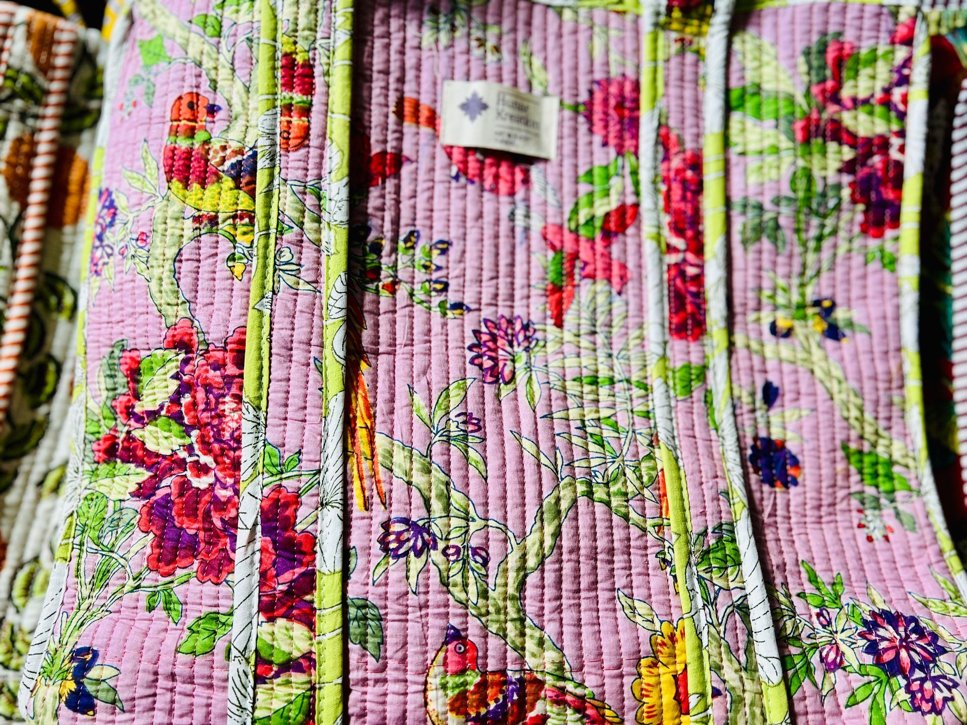 A close up of a pink quilt with flowers on it.