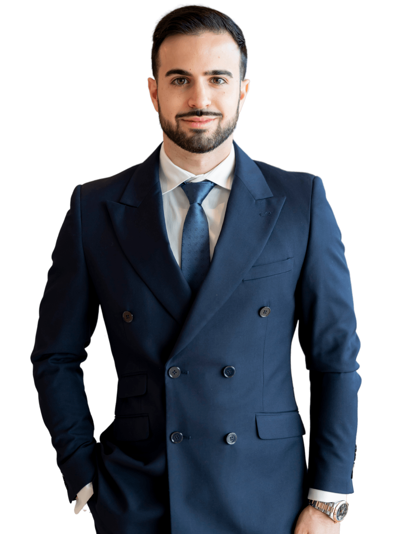 A man in a suit and tie is standing with his hands in his pockets.