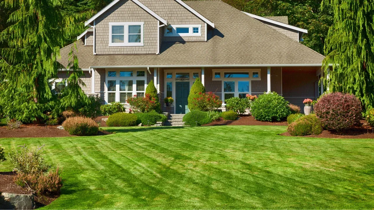 A large tan house with green front yard