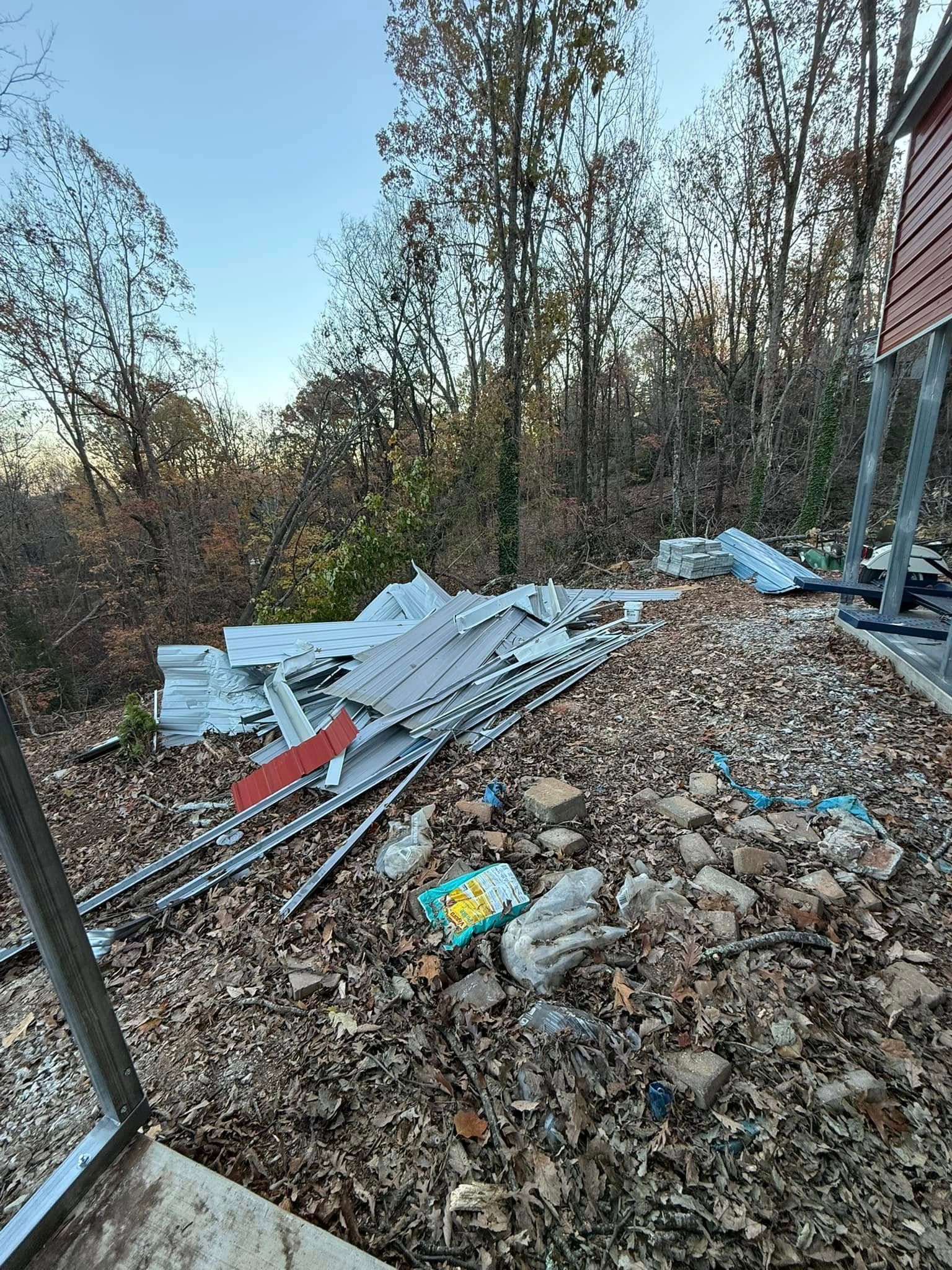Pile of construction debris, metal sheets, bricks, and leaves outdoors.