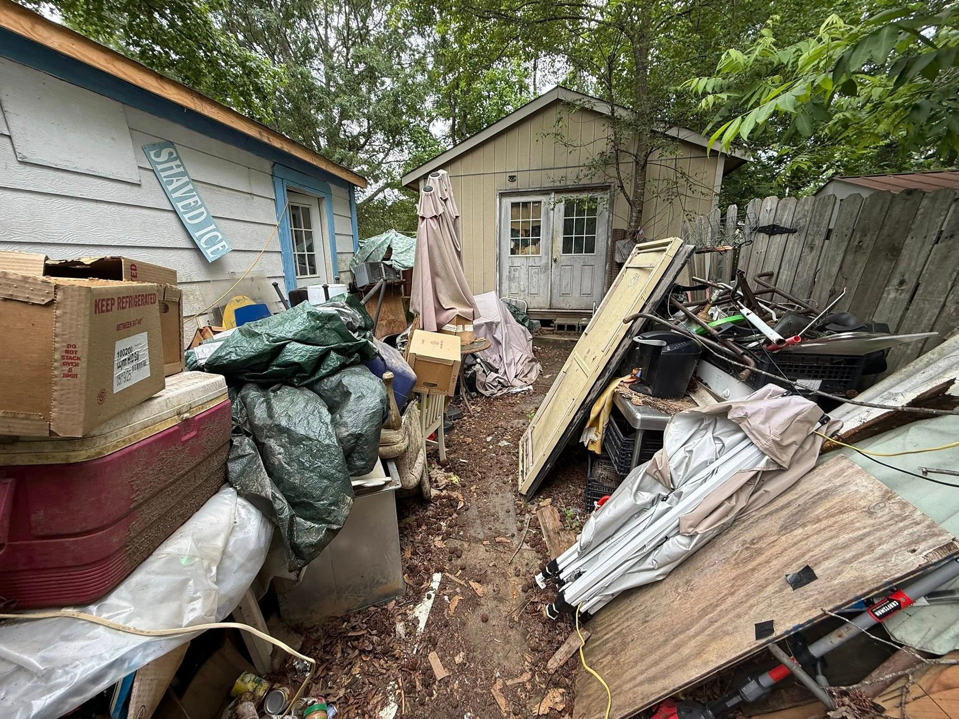 Backyard with cluttered debris and small shed.