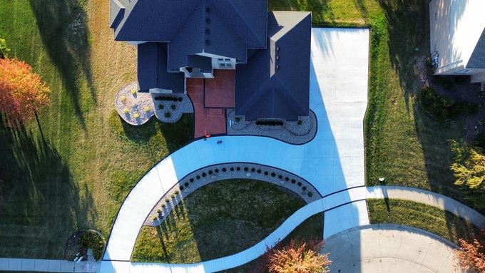 Construction of a concrete walkway around a residential rural house in manual of the pavement with a special tool.