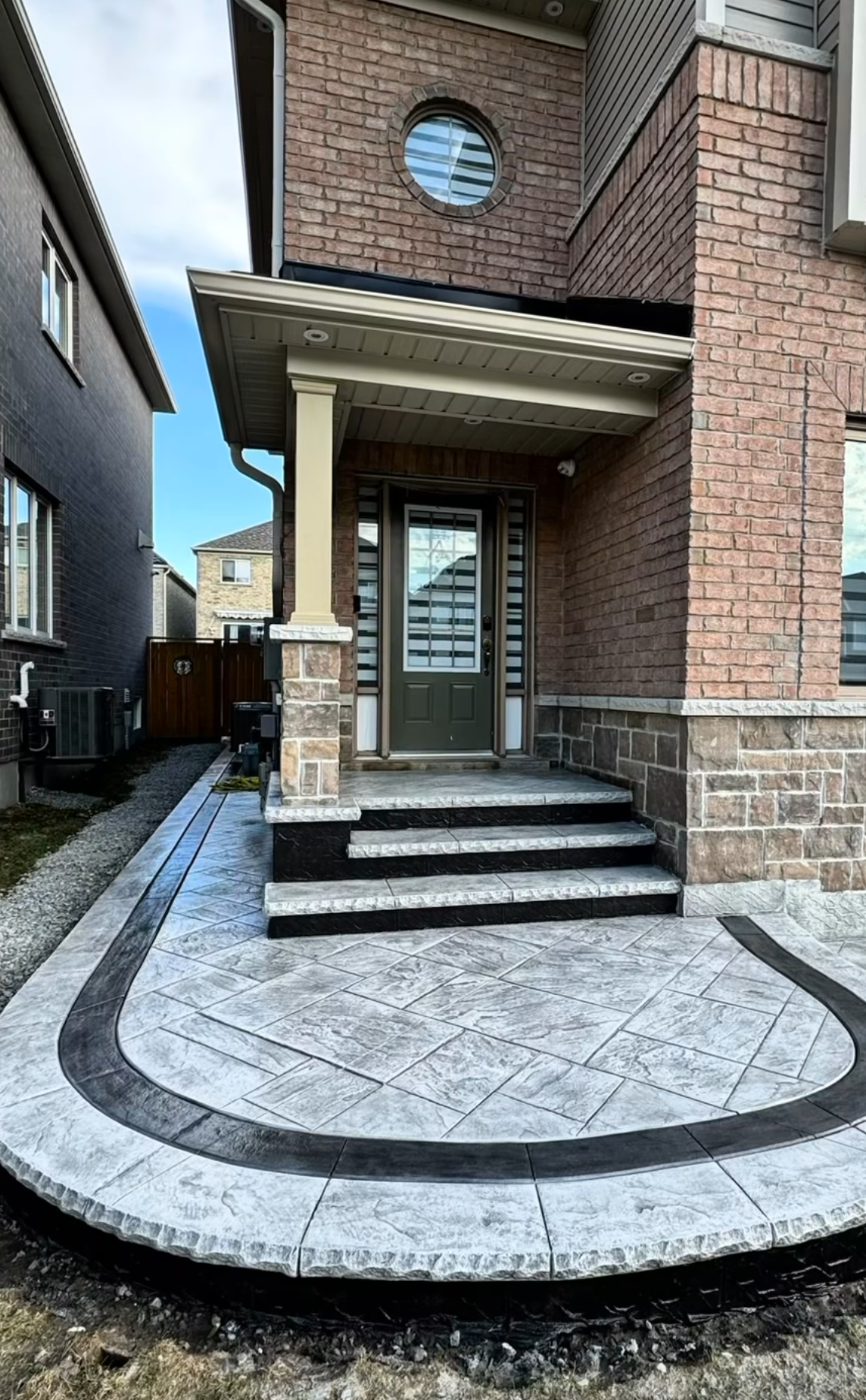 Clapboard siding house with walkout deck and concrete walkway.